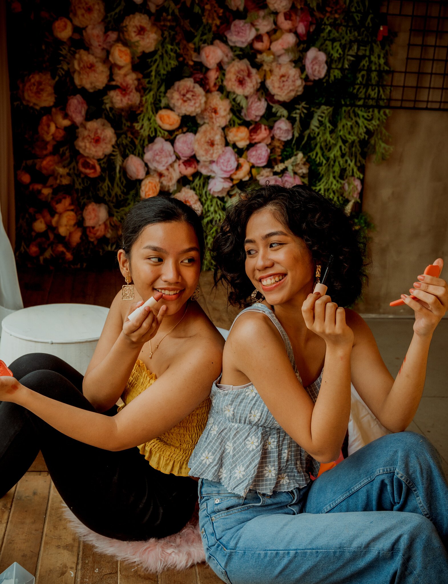 Smiling Women Applying Lipstick and Mascara on Face